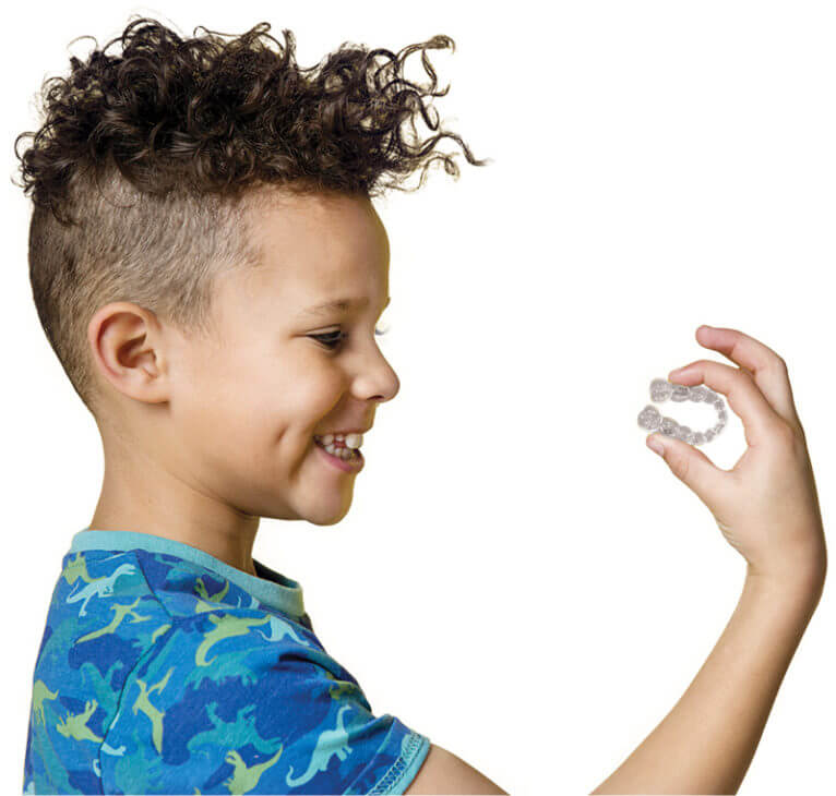 Young boy holding invisalign retainers